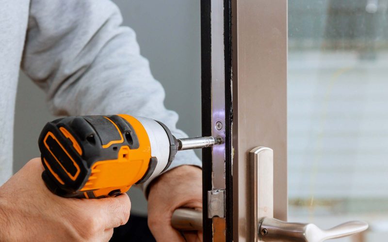 locksmith-in-installing-new-house-door-lock-hand-h-XVHVTG4.jpg